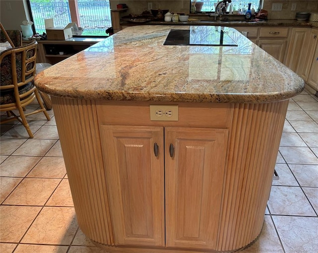 2001 Woodhill Rd, Edmond, OK 73025 - kitchen with a center island, light stone countertops, a sink, light tile patterned floors, and black electric stovetop