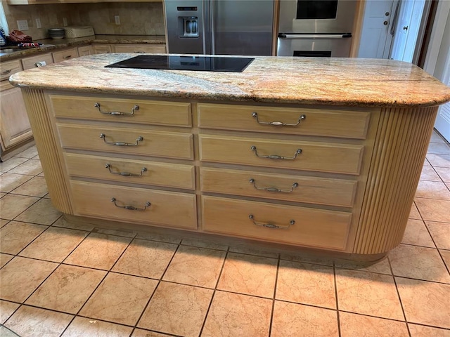 2001 Woodhill Rd, Edmond, OK 73025 - kitchen with appliances with stainless steel finishes, cream cabinets, light stone countertops, a center island, and light tile patterned flooring