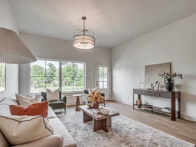 living area featuring baseboards and light wood-type flooring