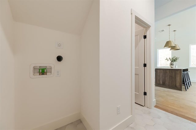 laundry area with washer hookup, light tile patterned floors, and baseboards