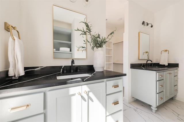 bathroom with a sink, two vanities, and marble finish floor