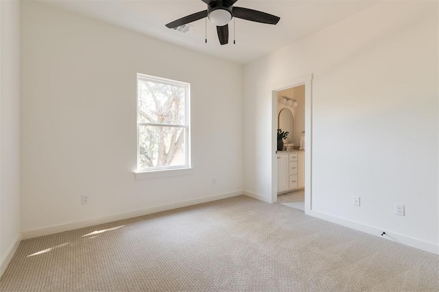 empty room with ceiling fan, light carpet, baseboards, and visible vents