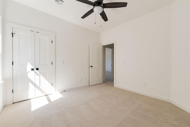 unfurnished bedroom with a closet, visible vents, baseboards, ceiling fan, and light colored carpet