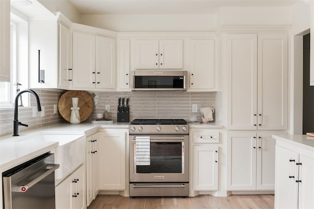 10912 Willow Grove Rd, Oklahoma City, OK 73120 - kitchen featuring white cabinetry, light wood-style flooring, appliances with stainless steel finishes, and light countertops