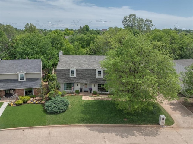 10912 Willow Grove Rd, Oklahoma City, OK 73120 - view of front of house with a chimney, a shingled roof, a front yard, and concrete driveway
