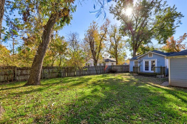 2929 NW 12th St, Oklahoma City, OK 73107 - view of yard featuring french doors, a wooden deck, and a fenced backyard