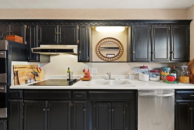 kitchen featuring a sink, light countertops, dark cabinetry, under cabinet range hood, and stainless steel appliances