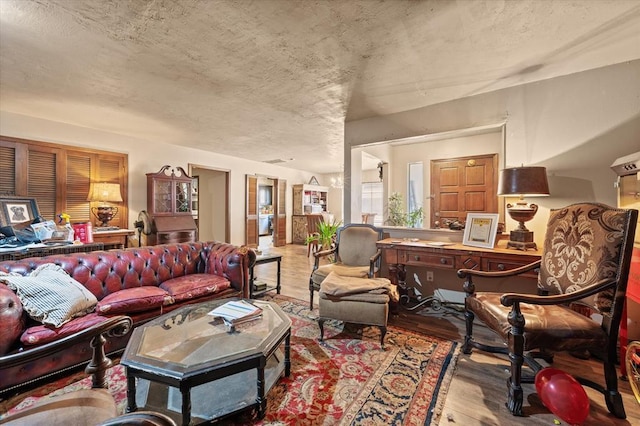 living area featuring wood finished floors and a textured ceiling