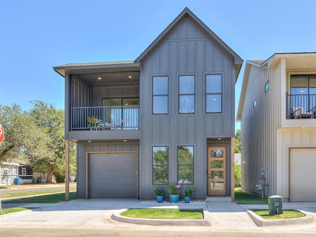 8 S Howard St, Edmond, OK 73003 - view of front facade with a balcony, board and batten siding, concrete driveway, and an attached garage