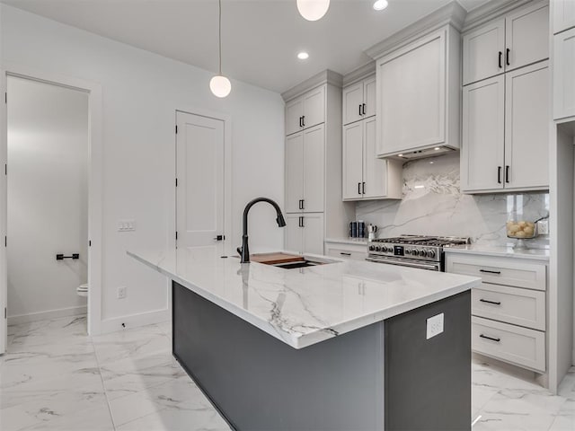 8 S Howard St, Edmond, OK 73003 - kitchen featuring marble finish floor, a kitchen island with sink, a sink, high end stainless steel range oven, and tasteful backsplash