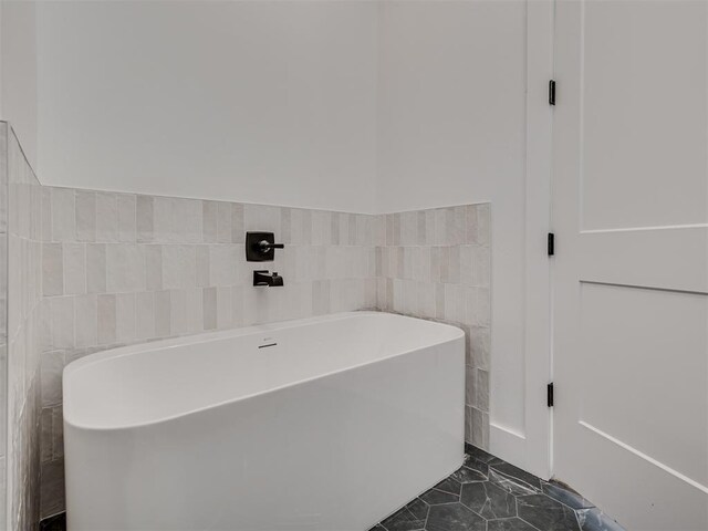8 S Howard St, Edmond, OK 73003 - bathroom with tile patterned flooring, a soaking tub, tile walls, and wainscoting