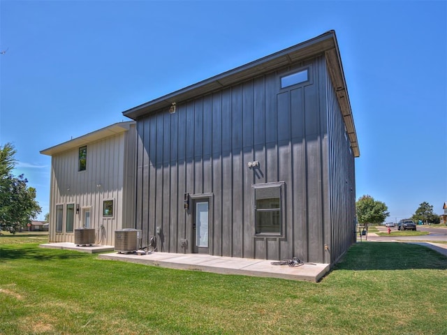 8 S Howard St, Edmond, OK 73003 - rear view of house featuring a yard, board and batten siding, and central AC