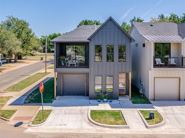 8 S Howard St, Edmond, OK 73003 - view of front facade featuring a balcony, an attached garage, board and batten siding, and driveway