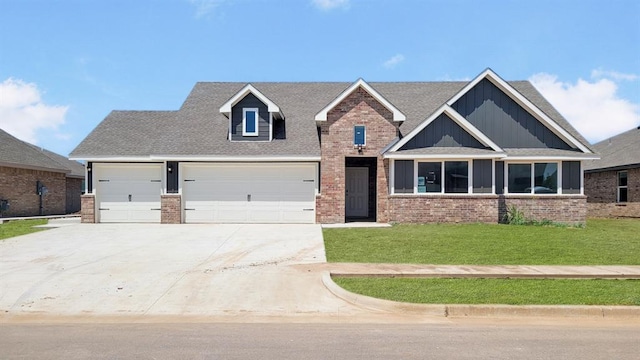 5412 Windstone Ln, Norman, OK 73072 - view of front of home with concrete driveway, a front yard, board and batten siding, brick siding, and an attached garage