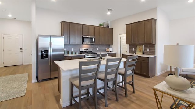 5412 Windstone Ln, Norman, OK 73072 - kitchen featuring appliances with stainless steel finishes, decorative backsplash, light countertops, dark brown cabinetry, and recessed lighting