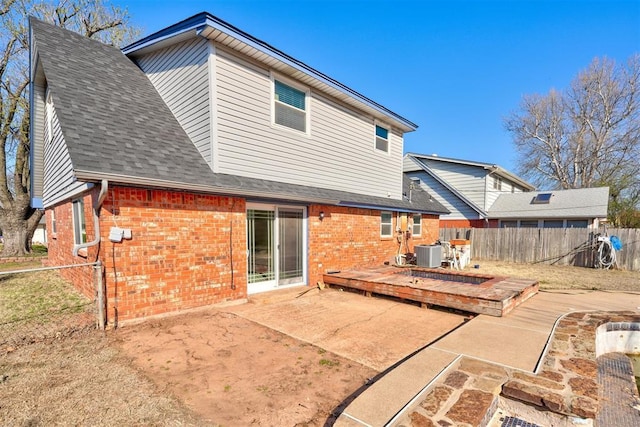rear view of property with a shingled roof, a fenced backyard, cooling unit, a wooden deck, and brick siding