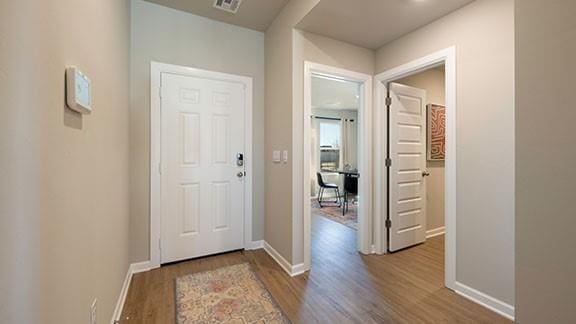foyer with visible vents, baseboards, and wood finished floors