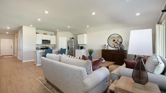living area featuring recessed lighting, light wood-style floors, and baseboards
