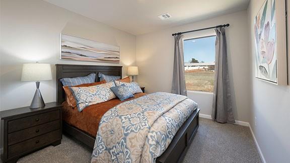 carpeted bedroom with visible vents and baseboards