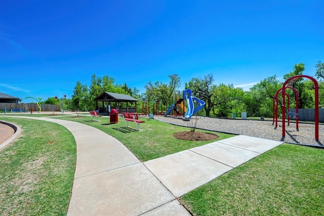 communal playground featuring a lawn and fence