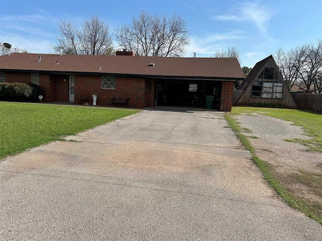 506 E Oklahoma St, Walters, OK 73572 - view of front of property featuring a front lawn, fence, a chimney, brick siding, and driveway