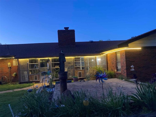 506 E Oklahoma St, Walters, OK 73572 - rear view of house with brick siding, a chimney, and a patio area