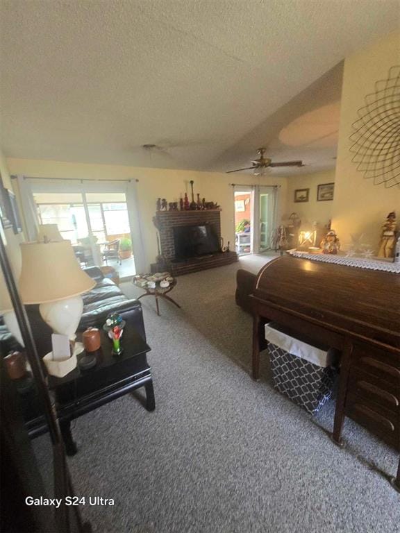 506 E Oklahoma St, Walters, OK 73572 - bedroom featuring a brick fireplace, access to exterior, ceiling fan, a textured ceiling, and carpet flooring