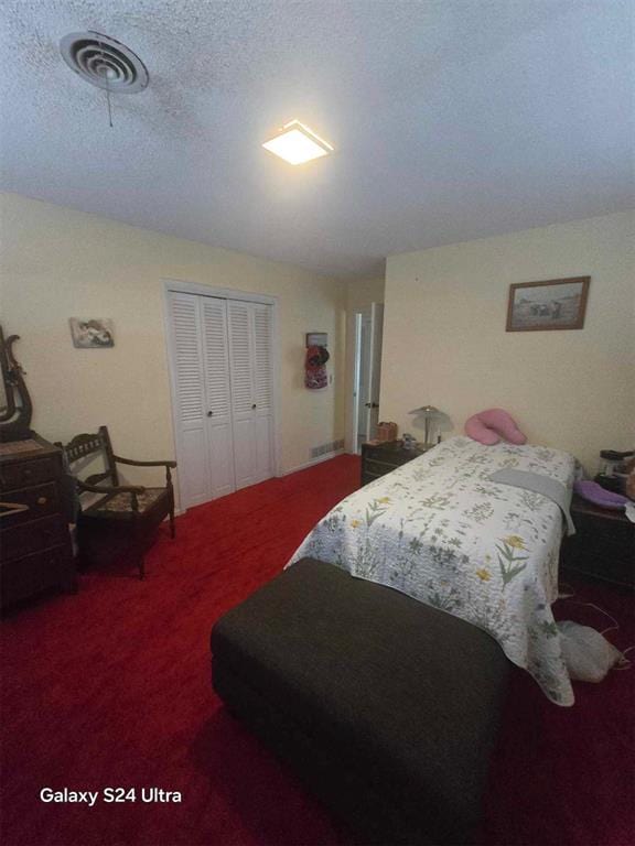 506 E Oklahoma St, Walters, OK 73572 - bedroom featuring carpet floors, a closet, a textured ceiling, and visible vents
