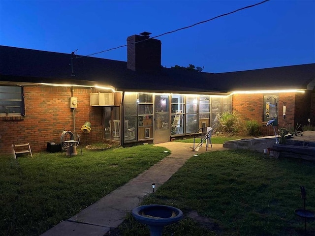 506 E Oklahoma St, Walters, OK 73572 - rear view of house featuring a lawn, a chimney, and brick siding
