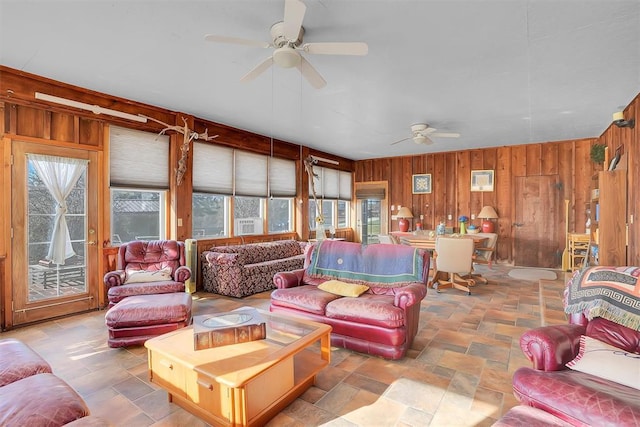 9872 N 2121st Pl, Butler, OK 73625 - living room with ceiling fan, wooden walls, and stone tile floors
