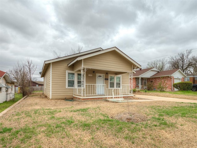 1604 NE Euclid St, Oklahoma City, OK 73117 - bungalow-style home with a porch, fence, and a front yard