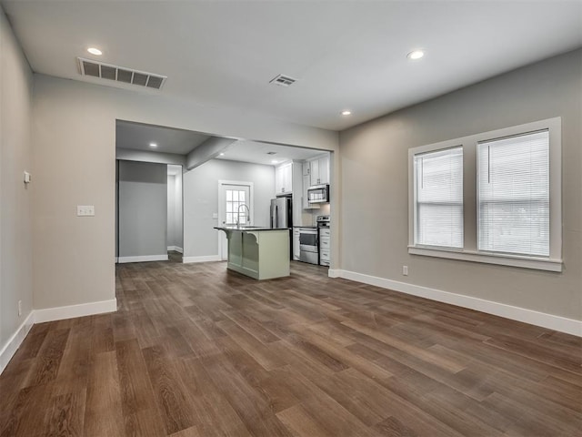 1604 NE Euclid St, Oklahoma City, OK 73117 - unfurnished living room with visible vents, dark wood-type flooring, a sink, recessed lighting, and baseboards