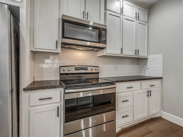 1604 NE Euclid St, Oklahoma City, OK 73117 - kitchen featuring dark stone countertops, baseboards, dark wood finished floors, appliances with stainless steel finishes, and tasteful backsplash