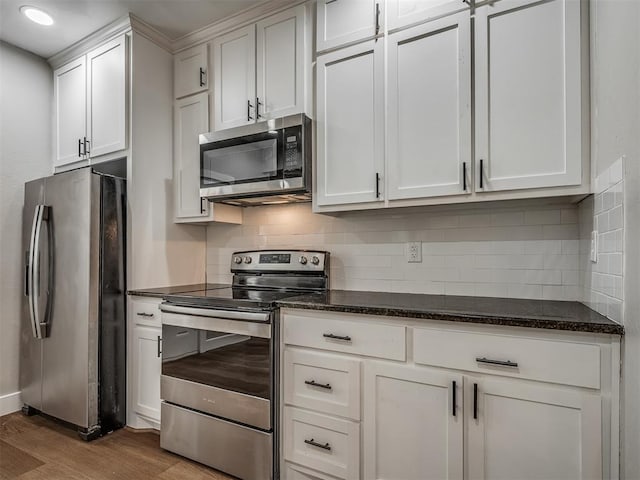 1604 NE Euclid St, Oklahoma City, OK 73117 - kitchen featuring light wood finished floors, backsplash, appliances with stainless steel finishes, and white cabinets