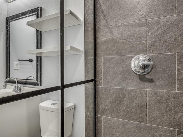 1604 NE Euclid St, Oklahoma City, OK 73117 - bathroom featuring toilet, tiled shower, and a sink