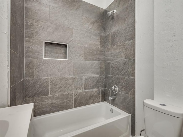 1604 NE Euclid St, Oklahoma City, OK 73117 - full bathroom featuring toilet, a textured wall, and shower / washtub combination