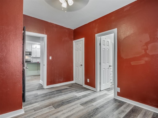 1604 NE Euclid St, Oklahoma City, OK 73117 - unfurnished bedroom with wood finished floors, baseboards, a textured wall, and ceiling fan