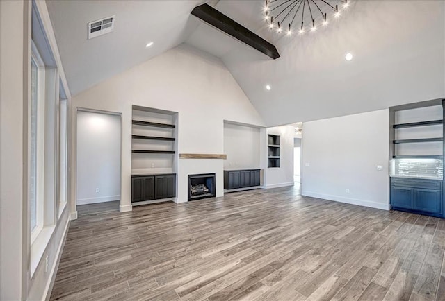 4201 Emery Dr, Edmond, OK 73034 - unfurnished living room featuring a chandelier, built in features, high vaulted ceiling, baseboards, and a fireplace