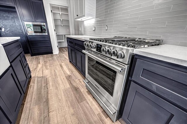 4201 Emery Dr, Edmond, OK 73034 - kitchen with stainless steel appliances, light stone countertops, backsplash, and light wood finished floors