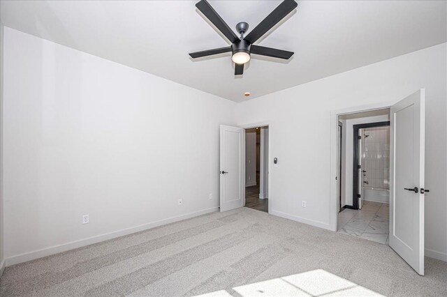 4201 Emery Dr, Edmond, OK 73034 - unfurnished bedroom featuring light colored carpet, baseboards, ensuite bathroom, and ceiling fan
