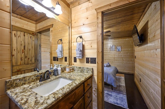 bathroom with wooden walls, wood ceiling, and vanity