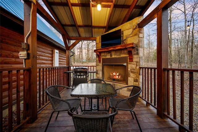 balcony with an outdoor stone fireplace, outdoor dining space, and area for grilling