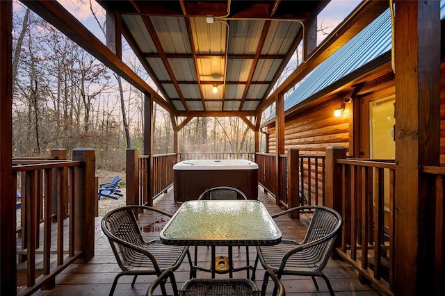 deck with a jacuzzi and outdoor dining area
