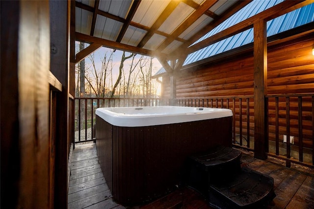 deck at dusk with a hot tub