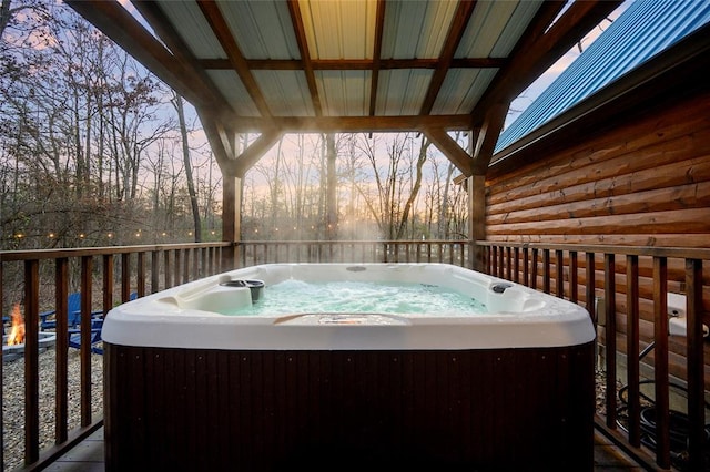 deck at dusk with a hot tub