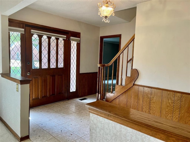 10900 Willow Grove Rd, Oklahoma City, OK 73120 - entryway featuring wainscoting, wood walls, a chandelier, and stairway