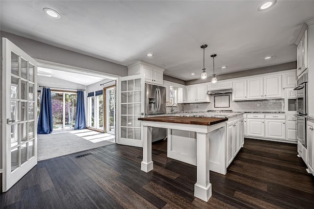 10900 Willow Grove Rd, Oklahoma City, OK 73120 - kitchen featuring wooden counters, stainless steel appliances, french doors, dark wood finished floors, and vaulted ceiling