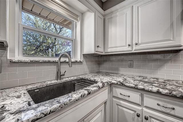 10900 Willow Grove Rd, Oklahoma City, OK 73120 - kitchen featuring a sink, white cabinets, backsplash, and light stone countertops