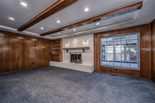 10900 Willow Grove Rd, Oklahoma City, OK 73120 - unfurnished living room featuring dark colored carpet, wood walls, a brick fireplace, beam ceiling, and recessed lighting