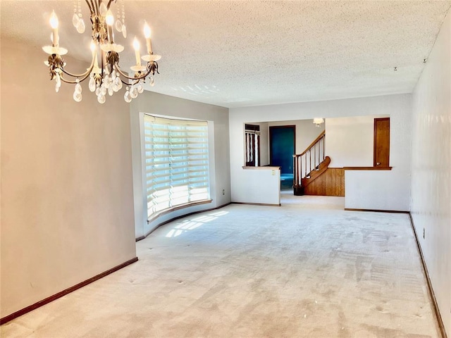 10900 Willow Grove Rd, Oklahoma City, OK 73120 - carpeted empty room with a textured ceiling, a chandelier, stairs, and baseboards